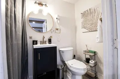 a bathroom with a white toilet and a mirror at BRANDNEW 2023 LAKEFRONT APT in Kissimmee