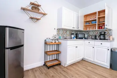 a kitchen with white cabinets and a stainless steel refrigerator at NEW5 APT NrUCF PETSOK PRIVATE patioENTRY LAUNDRY in Orlando