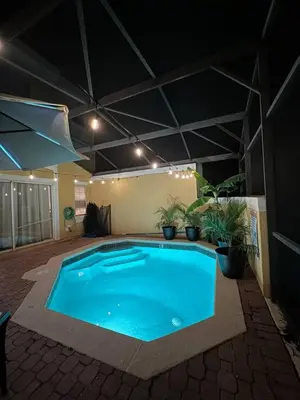 a large swimming pool in a room with plants at Magical Themed Home, Potter, Peter Pan 3mi Disney in Kissimmee