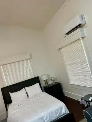 a bedroom with a bed and a air conditioner on the wall at Renovated Peaceful Luxury Walk to Mall Park Publix in Orlando