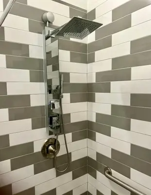 a bathroom with a shower with gray and white tiles at Renovated Peaceful Luxury Walk to Mall Park Publix in Orlando