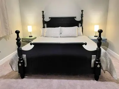 a black bed in a bedroom with two lamps at The Sanford Bandstand in Sanford