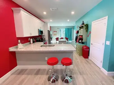 a kitchen with two red stools at a counter at The Sanford Bandstand in Sanford