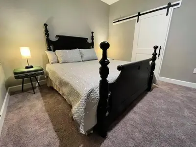 a bedroom with a large black bed and a lamp at The Sanford Bandstand in Sanford