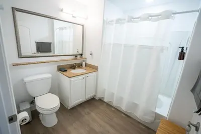 a bathroom with a toilet and a sink and a mirror at Orlando 4th Floor - 5 min Disney in Orlando