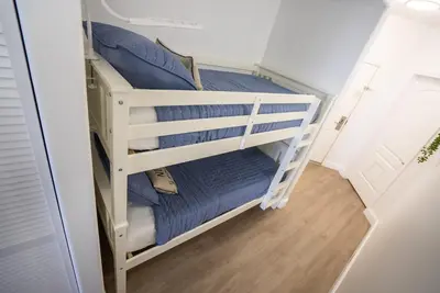a bunk bed in a small room with blue pillows at Orlando 4th Floor - 5 min Disney in Orlando