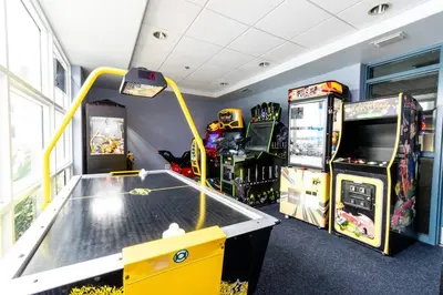 a room with a ping pong table and two arcade games at Orlando 4th Floor - 5 min Disney in Orlando
