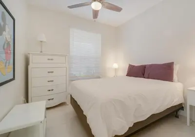 a bedroom with a white bed and a white dresser at Wonderful Life at Windsor Hills in Orlando