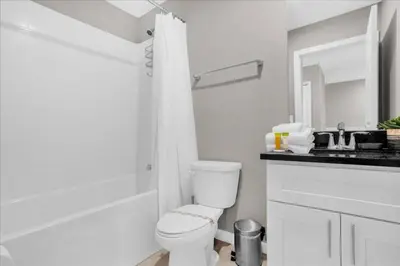 a white bathroom with a toilet and a sink at Themed Home Near Disney with Pool in Kissimmee