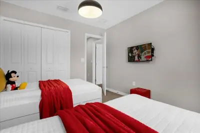 a bedroom with two white beds and a red blanket at Themed Home Near Disney with Pool in Kissimmee
