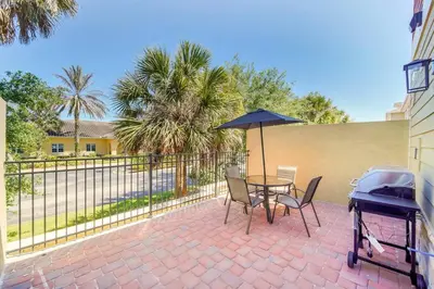a patio with a table and chairs and an umbrella at Enchanted Home Near Disney in Orlando