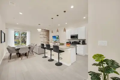 a white kitchen and dining room with a table and chairs at Enchanted Home Near Disney in Orlando