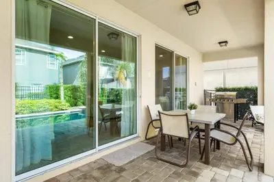 a patio with a table and chairs and a pool at Encore Resort 5 Bedroom Home with Pool 2403 in Orlando