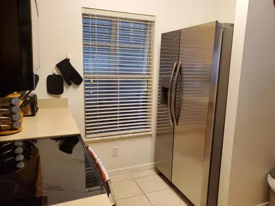 a kitchen with a stainless steel refrigerator and a window at Island Abode -near Disney in Kissimmee