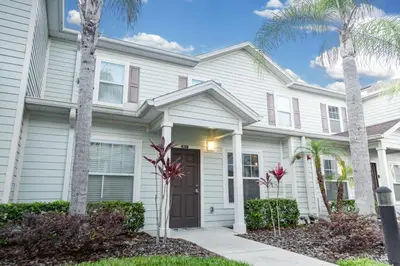 a white house with palm trees in front of it at Charming decorated 3BED at West Lucaya Resort 55 in Kissimmee