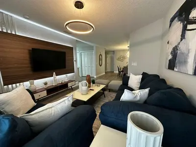 a living room with blue couches and a flat screen tv at Cozy apartment near Disney with 3 bedrooms 58 in Kissimmee