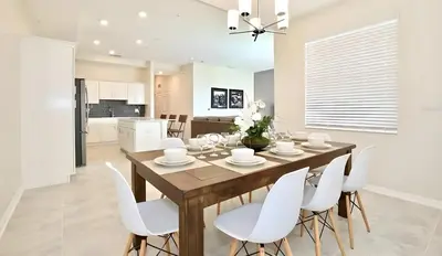 a kitchen and dining room with a wooden table and white chairs at 3BE&2BA Apartment at Storey Lake Resort 59 in Kissimmee