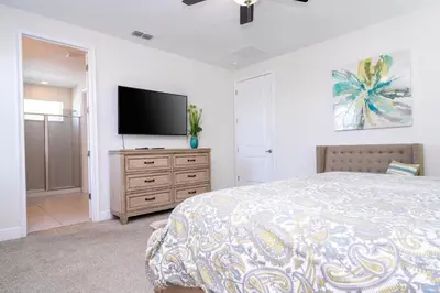 a bedroom with a bed and a flat screen tv at 510 BS - 5BD Cozy Family Haven with Pool in Orlando