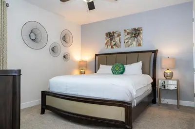 a bedroom with a large bed with white sheets at 510 BS - 5BD Cozy Family Haven with Pool in Orlando