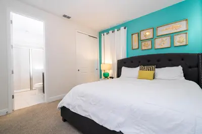 a bedroom with a large bed with a blue wall at 510 BS - 5BD Cozy Family Haven with Pool in Orlando