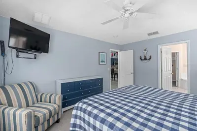 a bedroom with a bed and a chair and a ceiling fan at Private Pool Close to Disney Lg Hm Slps 8 in Kissimmee