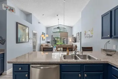 a kitchen with a sink and a living room at Private Pool Close to Disney Lg Hm Slps 8 in Kissimmee