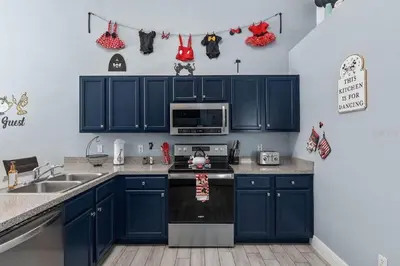 a kitchen with blue cabinets and a stove top oven at Private Pool Close to Disney Lg Hm Slps 8 in Kissimmee