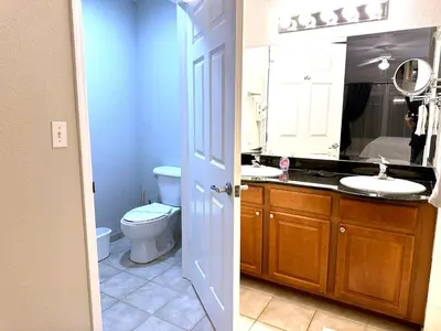 a bathroom with a toilet and a sink and a mirror at Star Wars-themed condo near Disney, Sea World, Universal and OCCC with pool, spa, restaurants, shuttle, and private balcony in Orlando