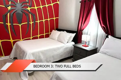 two beds in a hotel room with a red and yellow wall at Spider-Man-themed condo near Disney, Sea World, Universal and OCCC with pool, spa, restaurants, shuttle, private balcony, and view of fireworks shows in Orlando