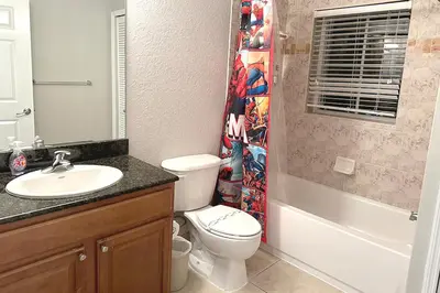 a bathroom with a toilet and a sink and a shower at Spider-Man-themed condo near Disney, Sea World, Universal and OCCC with pool, spa, restaurants, shuttle, private balcony, and view of fireworks shows in Orlando