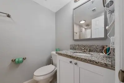 a bathroom with a toilet and a sink and a mirror at 2 suites ground floor apartment near Intern Drive in Orlando
