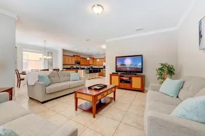a living room with two couches and a tv at Spacious 6BR family villa, 10 min to Disney, private pool, resort waterpark in Kissimmee