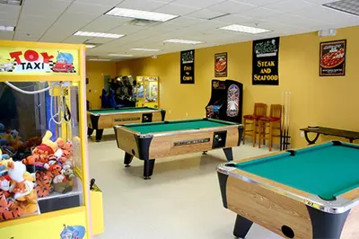 a gaming room with pool tables and arcade games at Lion King-themed condo near Disney, Sea World, Universal and OCCC with pool, spa, restaurants, shuttle, private balcony, and the BEST view of fireworks shows in Orlando