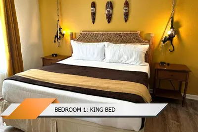 a bedroom with a bed with two night stands and two tables at Lion King-themed condo near Disney, Sea World, Universal and OCCC with pool, spa, restaurants, shuttle, private balcony, and the BEST view of fireworks shows in Orlando