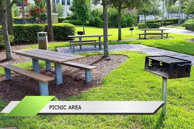 a picnic area with three picnic tables and a grill at Marvel-Themed, Spacious Condo Near OCCC, Sea World, Disney, and Universal with Extra Amenities in Orlando