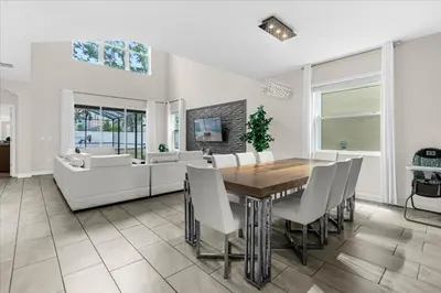 a dining room with a table and chairs and a couch at 5 Bedrroms 5 Bathrooms Storey Lake 2739 Bd in Kissimmee
