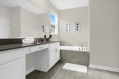 a white bathroom with a sink and a bath tub at 5 Bedrroms 5 Bathrooms Storey Lake 2739 Bd in Kissimmee
