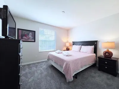 a bedroom with a large bed and a window at Luxurious 6Bd Pool Haven Refreshing and Chic-4464N home in Kissimmee