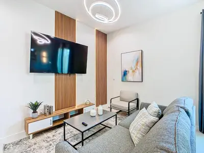 a living room with a couch and a flat screen tv at Fabulous Paradise 3BR Townhouse near Disney and outlets in Orlando