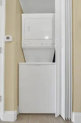 a white refrigerator with a washer and dryer in a room at K and J Orlando in Orlando