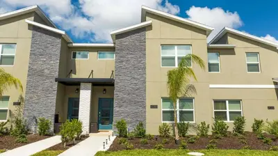 a house with a palm tree in front of it at Luxury Stay Near Disney Storey Lake Resort 2568 in Kissimmee