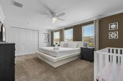 a bedroom with a white bed and a ceiling fan at Lake View Cozy Home w/ Pool & Games Near Disney in Kissimmee