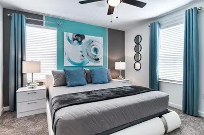 a bedroom with a large bed with blue walls and windows at Magical 10-Bedroom Disney Getaway Awaits! in Kissimmee