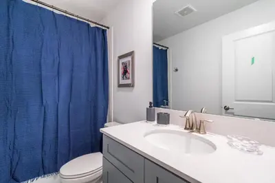 a bathroom with a sink and a blue shower curtain at Magical 10-Bedroom Disney Getaway Awaits! in Kissimmee