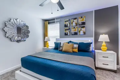 a bedroom with a blue bed and a mirror at Magical 10-Bedroom Disney Getaway Awaits! in Kissimmee