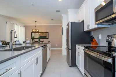 a kitchen with white cabinets and a black refrigerator at Fantastic Mickey house Waterpark near Disney 2572 in Kissimmee