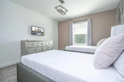 a white bedroom with two beds and a window at Fantastic Mickey house Waterpark near Disney 2572 in Kissimmee