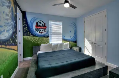 a bedroom with a bed with a football mural on the wall at All Vacation Mansion w Spa-Pool-Cinema Sleep 40 in Kissimmee