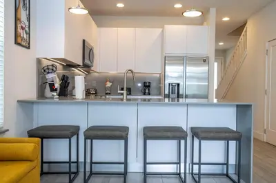 a kitchen with a counter with stools at a bar at Comfortable home Near Disney & Private Pool 17414 in Orlando