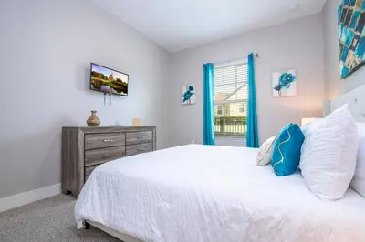 a bedroom with a white bed and a window at Stunning Villa 5 min to Disney in Orlando